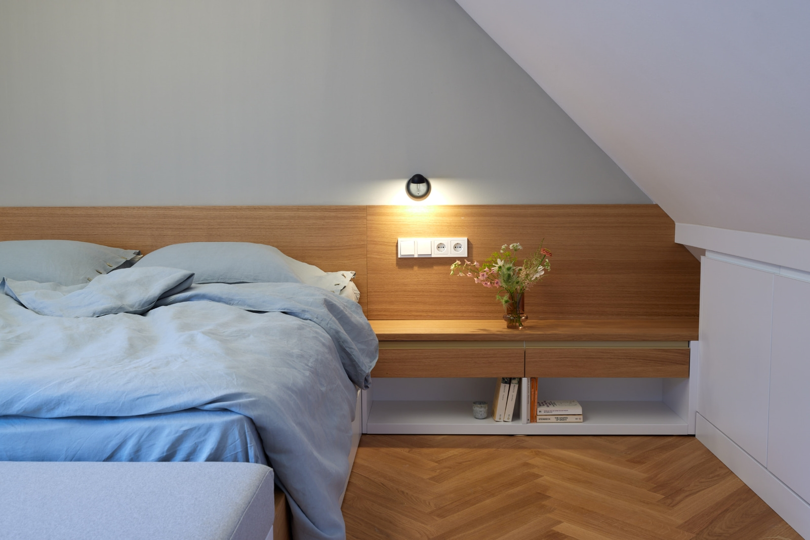 Schlafzimmerausbau Wien: modernes Bett mit integrierten Möbeln, Holzdetails und minimalistischer Gestaltung