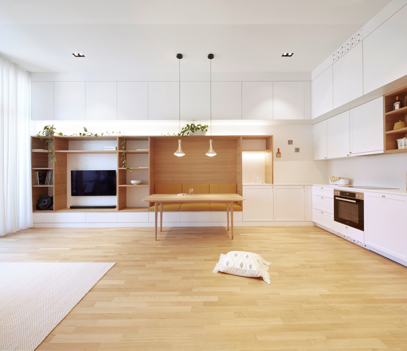 Wohnküche mit integriertem Regal, Sitzbereich und heller Holzgestaltung – klare Architektur für urbanes Wohnen.