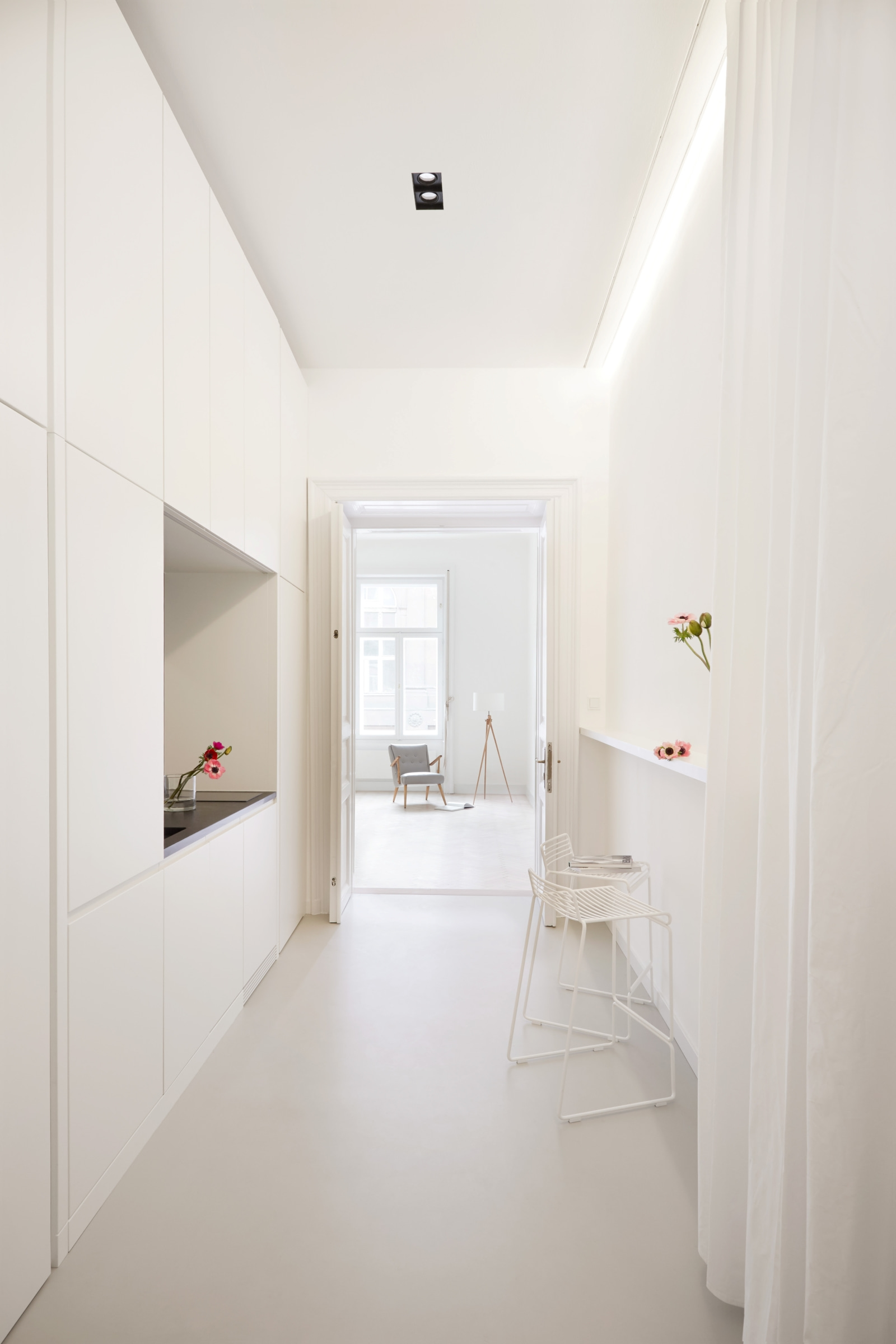 Ansicht der schmalen Küchenzeile im Trennmöbel, Blick in den hellen Wohnraum.