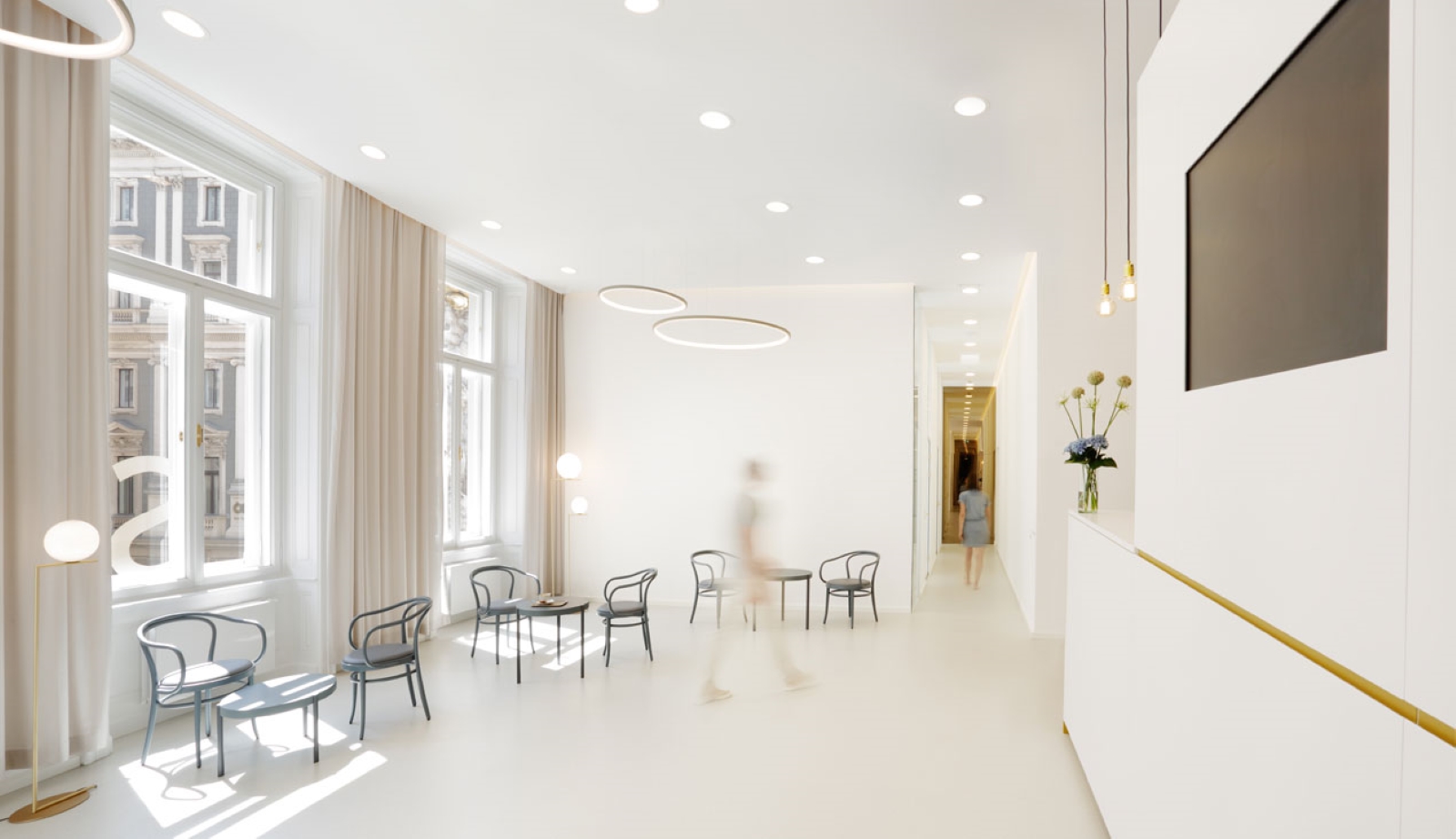 Heller Wartebereich der Zahnklinik mit Sitzmöbeln und großen Fenstern.