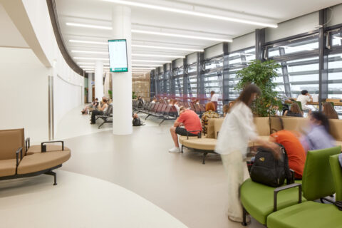 Übersicht der Besucherwartezone mit Sitzplätzen, Informationsdisplays und Blick auf das Rollfeld.