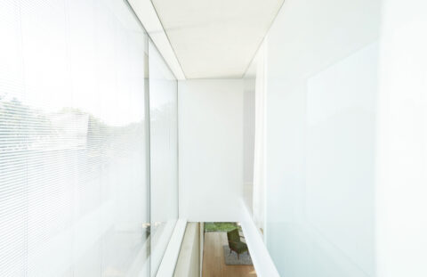 Transparenter Glasgang mit Ausblick, minimalistische Details und helle Materialien prägen das moderne Wohnkonzept.