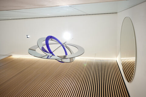 Schwebende Glaselemente und Spiegelringe in Blau und Silber als Kunst am Bau Projekt in der Hypo Tirol Wien.