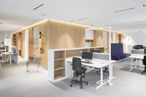 Modernes Großraumbüro mit Holzlamellenwand, offenen Arbeitsplätzen und klarer architektonischer Struktur für flexible Teamarbeit.