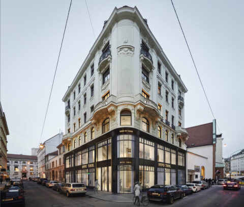 Historic corner building in Vienna with modern glass façade on the ground floor, home of HYPO Tirol Bank, elegant architecture in city center.
