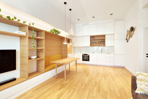 Moderne Wohnküche mit Einbaumöbeln, Holzdetails und heller Gestaltung – Architektur verbindet Wohnen und Kochen.