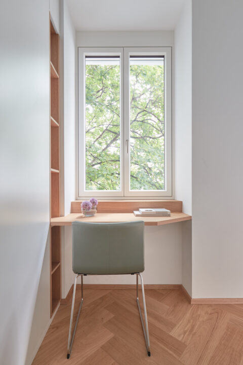 Heller Arbeitsplatz am Fenster mit Holzschreibtisch und integriertem Regal