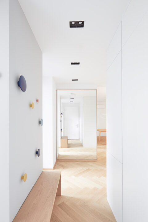 Heller Eingangsbereich mit Spiegel und Holzbank