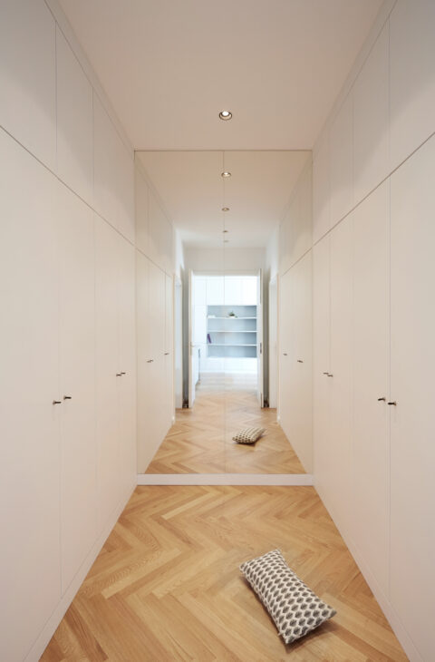 Langer Flur mit raumhohen Schränken und Spiegelwand, Kissen am Boden