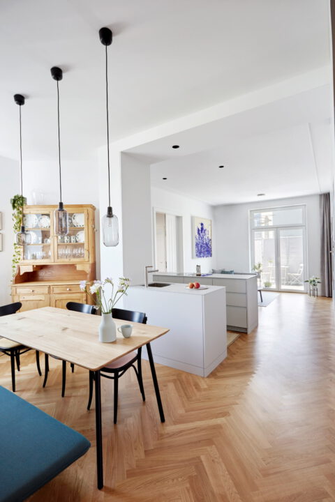 Essbereich mit Holztisch, Stühlen und Blick in die offene Küche