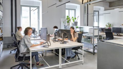 Team von Atelier Froehlich im Büro, vier Personen sitzen an ihren Arbeitsplätzen.